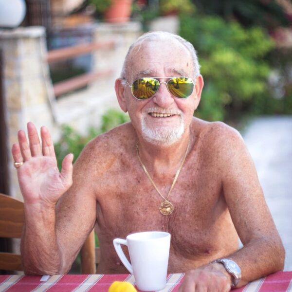 topless man wearing sunglasses sitting on chair